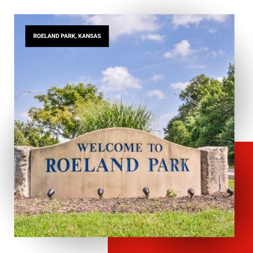 Welcome to Roeland Park stone entrance sign surrounded by green trees and landscaping under a blue sky