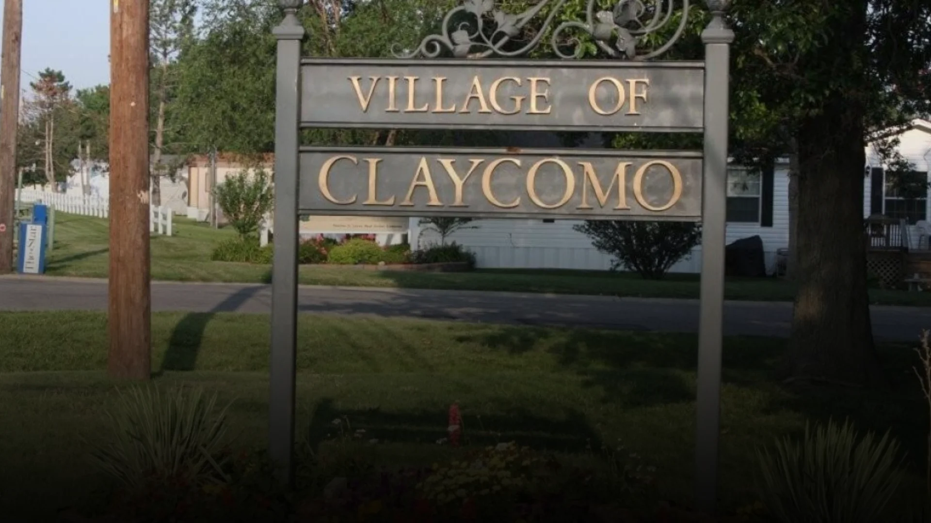 Welcome sign for the Village of Claycomo, Missouri, set on a grassy lawn in a residential neighborhood
